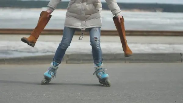 Jeune belle femme au chapeau rouge, portant des vêtements chauds et sportifs et des rouleaux, chevauchant sur la route sur la côte — Photo