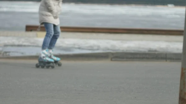 Jeune belle femme au chapeau rouge, portant des vêtements chauds et sportifs et des rouleaux, chevauchant sur la route sur la côte — Photo