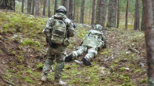 Soldados en camuflaje con armas de combate están siendo disparados en el refugio del bosque, el concepto militar — Vídeos de Stock
