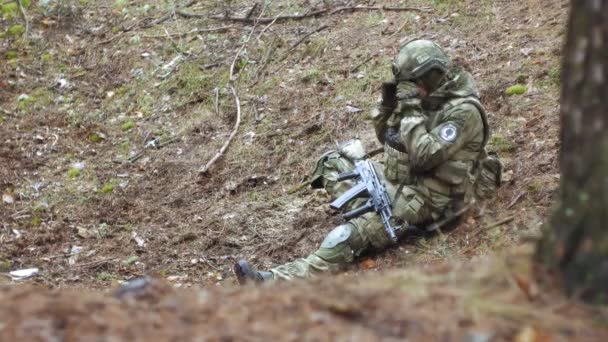 Soldados en camuflaje con armas de combate están siendo disparados en el refugio del bosque, el concepto militar — Vídeo de stock