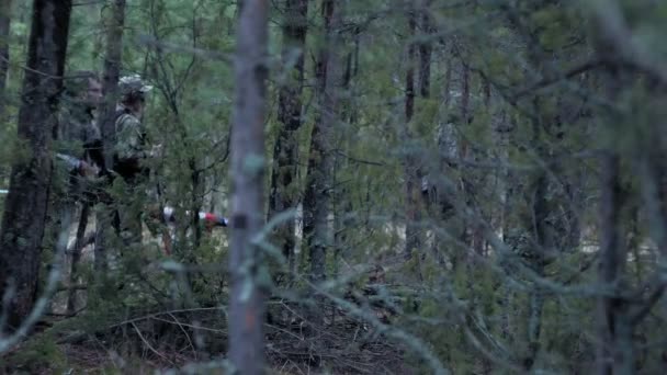 Soldater i kamouflage med bekämpa vapen gör sin väg utanför skogen, med syftet att fånga det, militära konceptet — Stockvideo