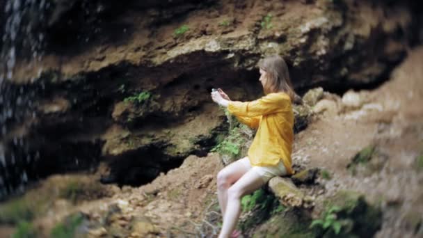 Utazás kaland nő fotózni egy smartphone, egy hegyi vízesést, a élvezi a gyönyörű táj, a természet — Stock videók
