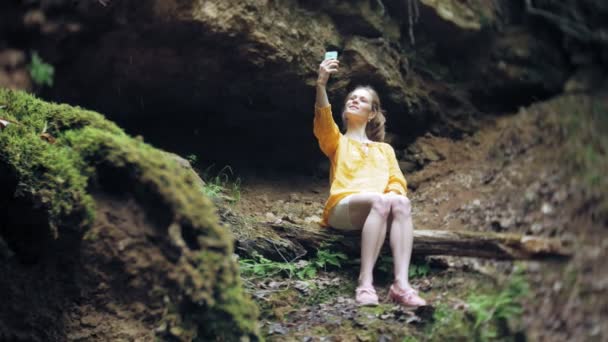 Viagem mulher aventura tirar fotos de um smartphone em uma cachoeira da montanha, apreciando a bela paisagem da natureza — Vídeo de Stock