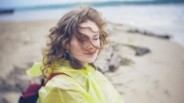 Mujer feliz caminando por la costa Viajando Estilo de vida aventura vacaciones al aire libre. Una chica vestida con un impermeable amarillo de moda — Vídeos de Stock