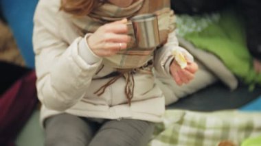 Nehir kıyısında turist çadır. yeme ve içme nehre bakar çadır yakınındaki iki kız oturuyor.