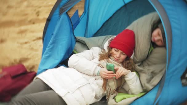 川の土手にテントを観光。2 つの女の子が川での飲食テント近くに座っています。. — ストック動画