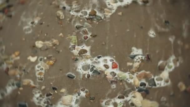 Des vagues de l'océan de la rivière tombent sur le rivage sablonneux de pierre . — Video