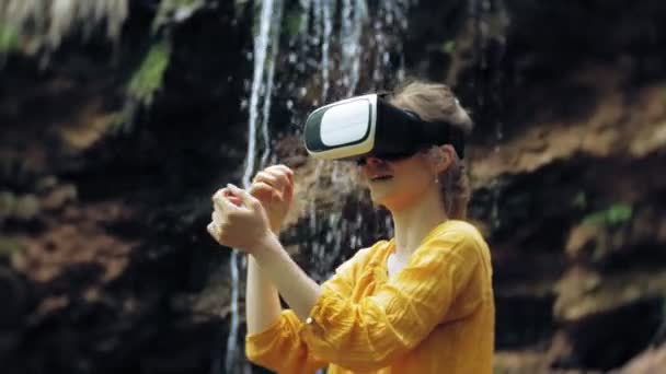 Dívka virtuální realita brýle Vr slunečný den přírody žena zvýšit ruce vrcholy hor, vodopád, lesní elektronické nositelné technologie využívající hra simulátor vizuální zážitek 3d kosmické inovace — Stock video