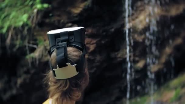 Ragazza occhiali realtà virtuale VR giornata di sole fauna selvatica donna alzando le mani picchi montagne, cascata, foresta elettronica indossabile tecnologia utilizzando simulatore di gioco esperienza visiva 3d innovazione cosmica — Video Stock