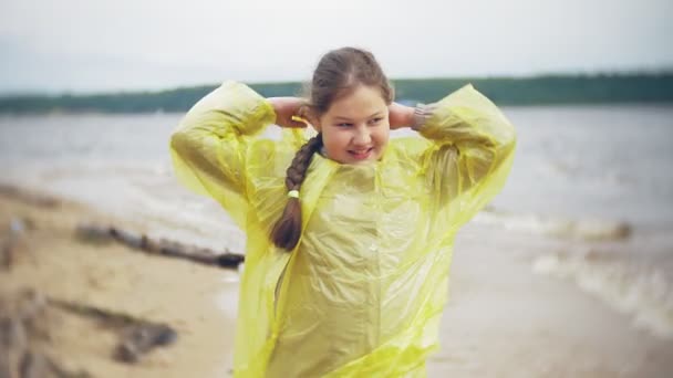 Szczęśliwa dziewczyna spaceru wzdłuż wybrzeża wakacje przygoda podróży życia na zewnątrz. Dziewczyna ubrana w modne żółty płaszcz — Wideo stockowe