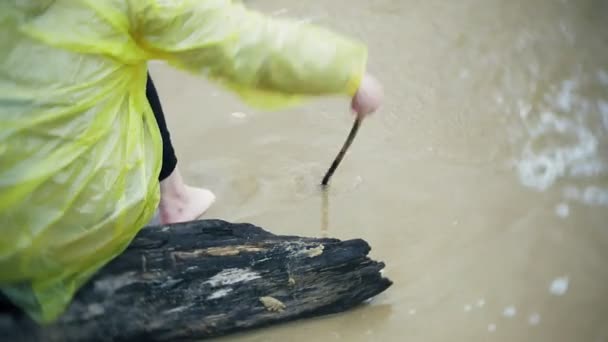 Gelukkig meisje wandelen langs de kust Lifestyle reizen avontuurlijke vakantie buitenshuis. Een meisje gekleed in een modieuze gele regenjas — Stockvideo