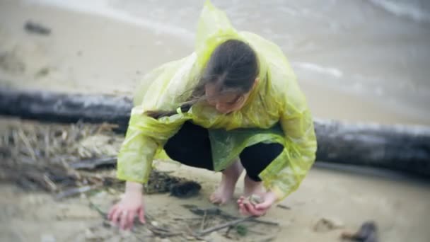 Chica feliz caminando a lo largo de la costa Viajar vacaciones aventura estilo de vida al aire libre. Una chica vestida con un impermeable amarillo de moda — Vídeos de Stock