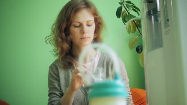 Uma mulher bebe um cocktail de oxigénio com um dispositivo para a escória de oxigénio. Cocktail de oxigénio para uma mulher. Uma mulher faz um coquetel de oxigênio com um dispositivo para oxi-poleiro — Vídeo de Stock