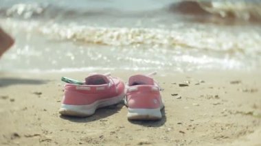 Sahilde Ayakkabı yaz. bir kız yürüyüş ve kumsalda dans arka planda