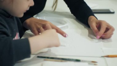 Çocuk kız birlikte sınıf ve onların parmak ve boya ile çizim masada oturmak. Onlarla birlikte onların genç ve güzel öğretmen.