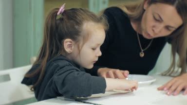 Çocuk kız birlikte sınıf ve onların parmak ve boya ile çizim masada oturmak. Onlarla birlikte onların genç ve güzel öğretmen.