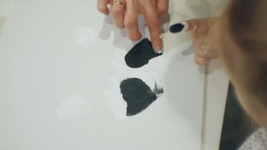 Çocuk kız birlikte sınıf ve onların parmak ve boya ile çizim masada oturmak. Onlarla birlikte onların genç ve güzel öğretmen.