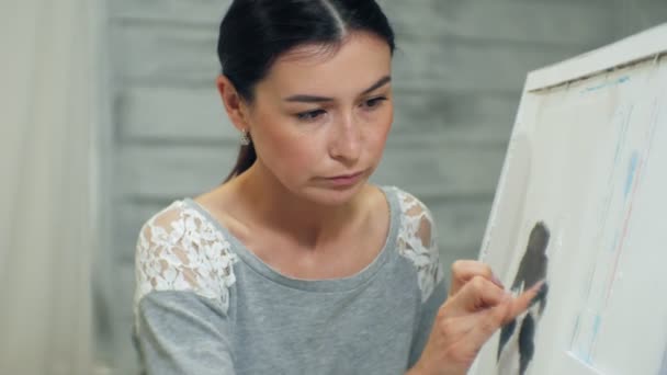 Eine junge hübsche Lehrerin zeichnet an einer Tafel, unterrichtet im Kunstunterricht — Stockvideo