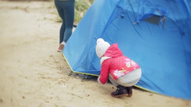 Сім'я дітей і матерів збирає туристичний намет на березі річки моря — стокове відео