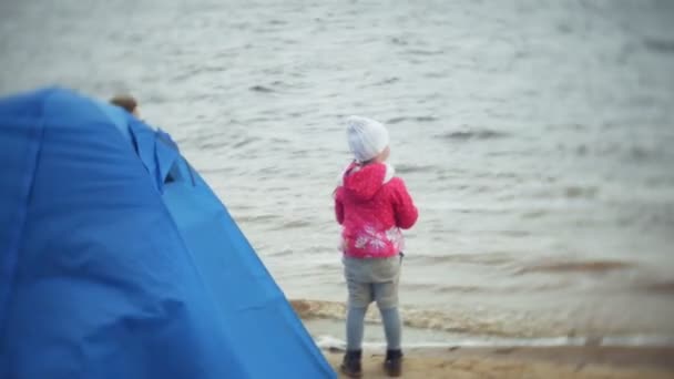 Mãe e filha felizes e bonitas estão alimentando gaivotas na praia na margem do rio — Vídeo de Stock