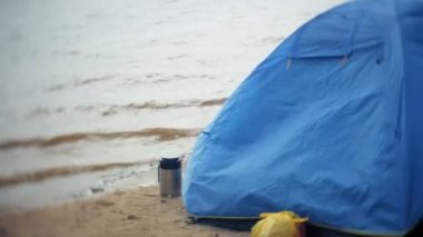 Adam bir turist çadır nehir deniz kıyısında toplar.