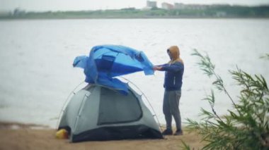 Adam bir turist çadır nehir deniz kıyısında toplar.