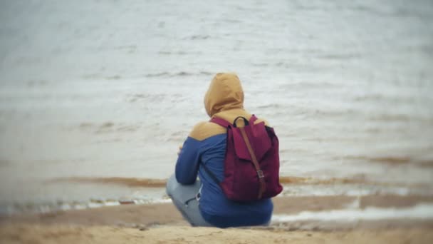 Man with a tourist backpack on the beach — Stock Video