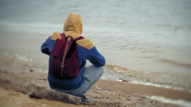Человек с туристическим рюкзаком на пляже — стоковое видео
