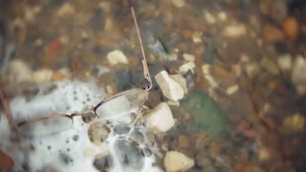 Punkte in einem runden Rahmen liegen am Ufer im Hintergrund der Wellen — Stockvideo