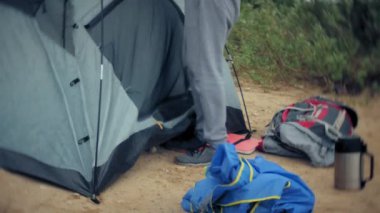 Adam bir turist çadır nehir deniz kıyısında toplar.
