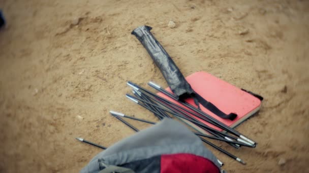 Man collects a tourist tent on the bank of the river of the sea — Stock Video