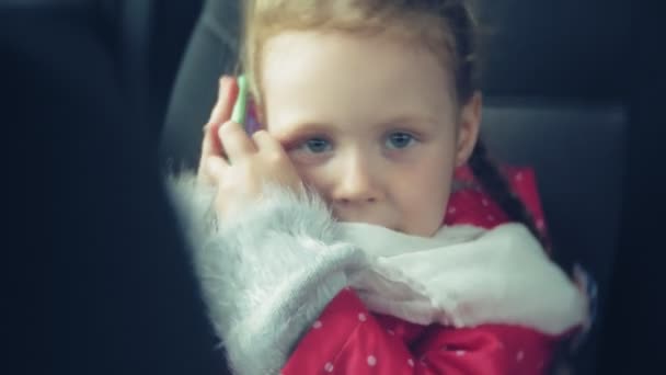 Chica feliz sentada en el asiento trasero de un coche y hablando por teléfono — Vídeos de Stock
