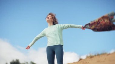 Bir kadın kum sahilde deniz kenarında, hayattan zevk yürüyor