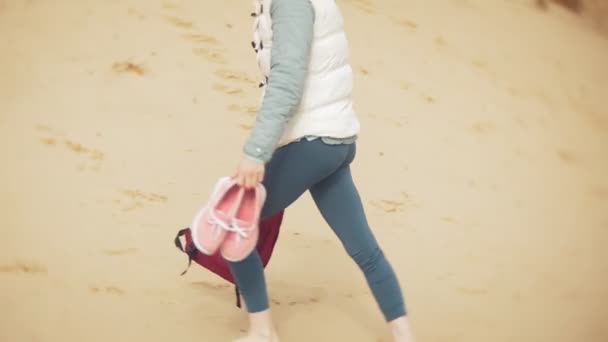 Bir kadın kum sahilde deniz kenarında, hayattan zevk yürüyor — Stok video