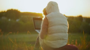 Eski vintage tren Köprüsü yakınlarında dizüstü bilgisayarda çalışan genç kadın.