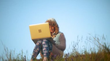 Eski vintage tren Köprüsü yakınlarında dizüstü bilgisayarda çalışan genç kadın.