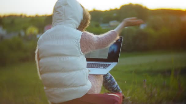 Junge Frau arbeitet an Laptop in der Nähe alter Eisenbahnbrücke. — Stockvideo