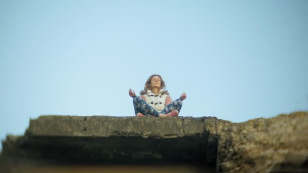 Eine junge Frau praktiziert Yoga in der Nähe einer alten Eisenbahnbrücke. — Stockvideo