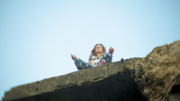 Una giovane donna pratica yoga vicino a un vecchio ponte ferroviario d'epoca . — Video Stock