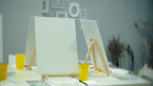 Art school, creativity and concept with easels, brushes and palettes, still life at the studio — Stock Video