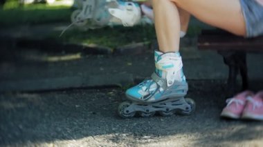 Tekerlekli paten parkta bankta oturan kadın Giydir