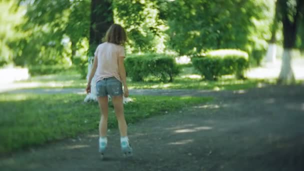 Женщина катается на роликах в парке — стоковое видео