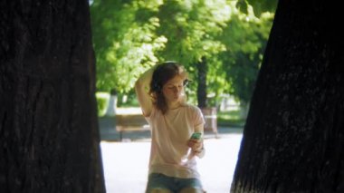 kadın paten ve kulaklıklar parkta telefonda müzik dinlemek