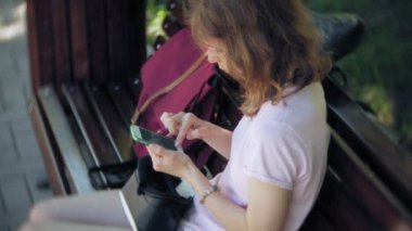 Genç kadın parkta başa takılı ekran kullanır. Akıllı telefonlar için VR-kask kullanarak oyun oyun. Mutlu