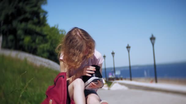 Jovem mulher usa display montado na cabeça no parque. Jogar jogo usando o capacete VR para telefones inteligentes. Feliz. — Vídeo de Stock