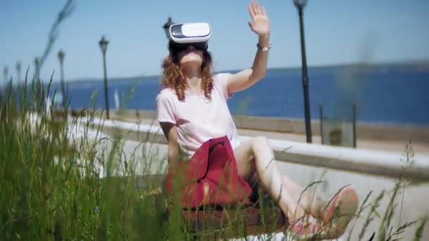 若い女性は、公園でヘッドマウントディス プレイを使用します。スマート フォン用 Vr ヘルメットを使用して遊ぶゲーム。幸せです — ストック動画