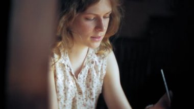 bir kadın bir restoranda bir kokteyl içer ve telefon kullanır