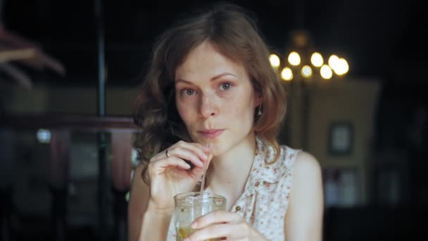 Женщина пьет коктейль в ресторане — стоковое видео