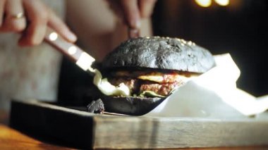 Genç kadın yemek lokanta, siyah hamburger