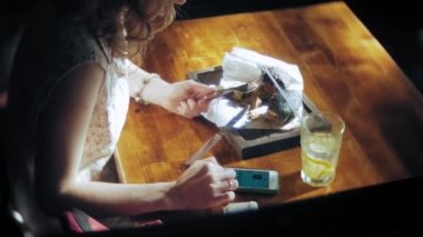 Genç kadın yemek lokanta, siyah hamburger